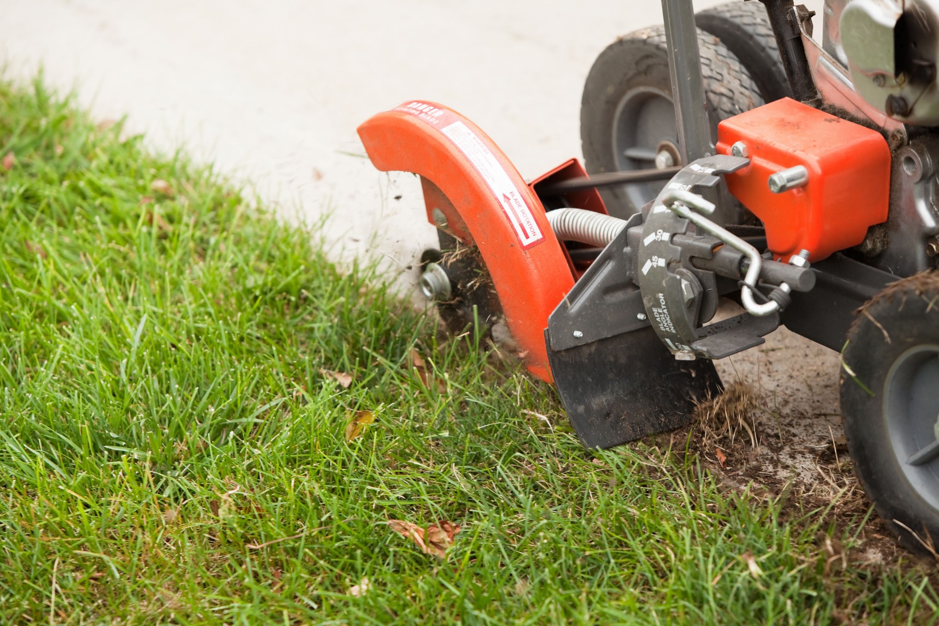 Lawn Edger Machine Edging Grass next to Sidewalk